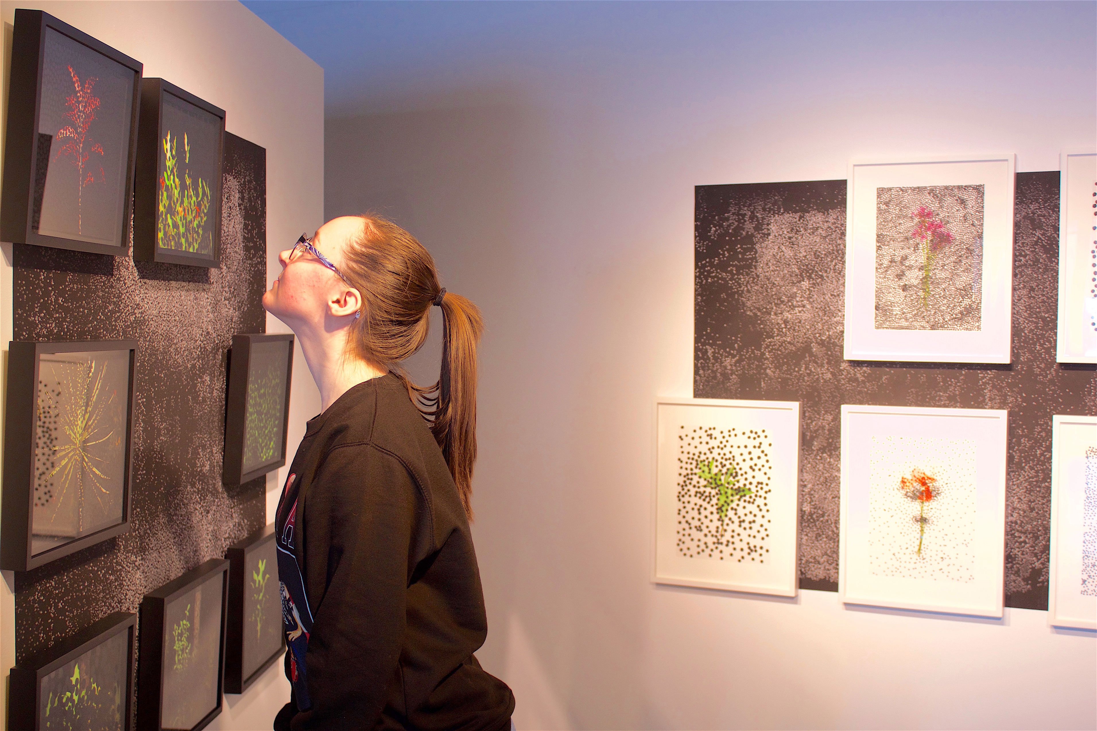 student looking at art on wall